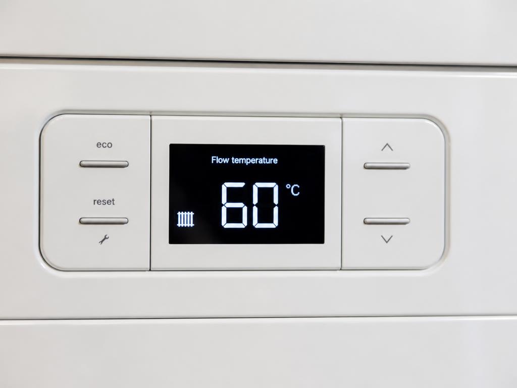 A digital boiler display showing 60°C flow temperature with up and down buttons